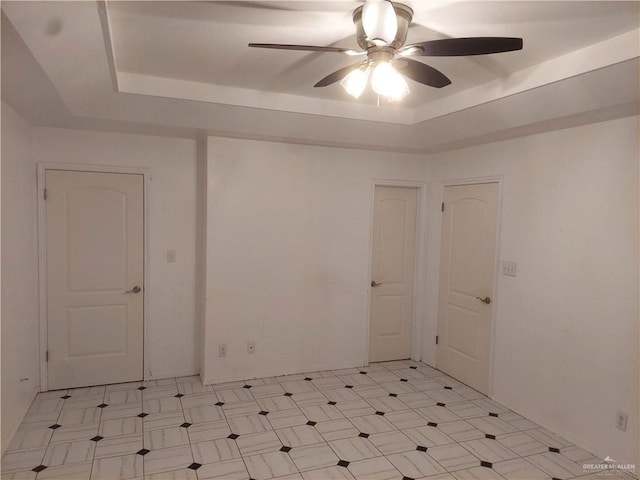 spare room with a raised ceiling and ceiling fan