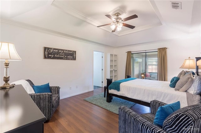 bedroom with ceiling fan, dark hardwood / wood-style flooring, ornamental molding, and a tray ceiling