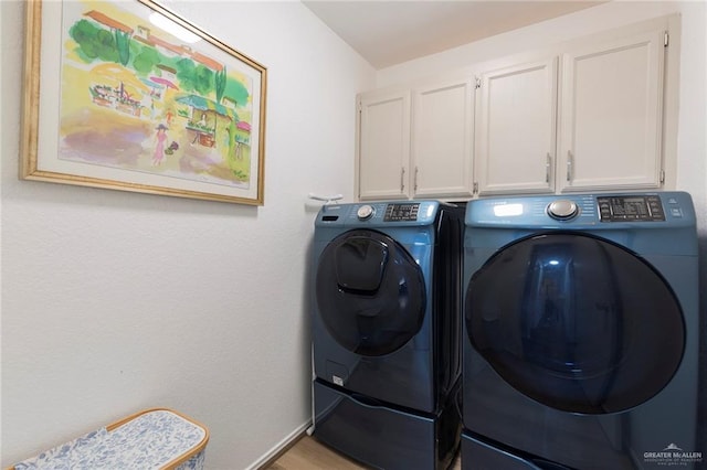 washroom with washing machine and dryer and cabinets