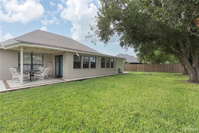 rear view of property with a lawn and a patio area