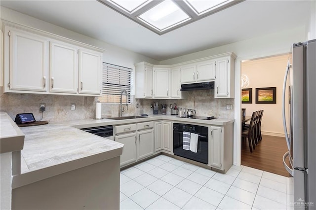 kitchen featuring white cabinetry, sink, kitchen peninsula, light tile patterned floors, and black appliances