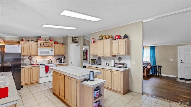 kitchen with tile counters, tasteful backsplash, vaulted ceiling, white appliances, and a kitchen island