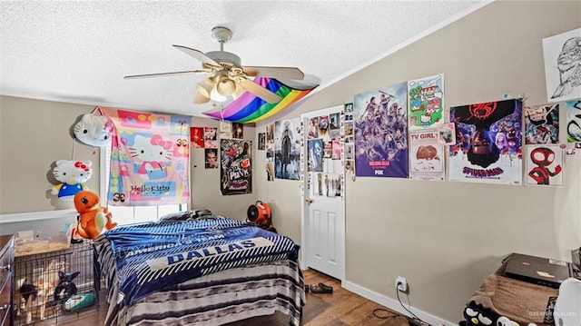 bedroom with ornamental molding, a textured ceiling, ceiling fan, wood-type flooring, and lofted ceiling