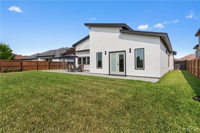 back of property with a yard, a patio, a fenced backyard, and stucco siding