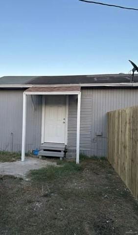 view of outdoor structure featuring entry steps, an outdoor structure, and fence