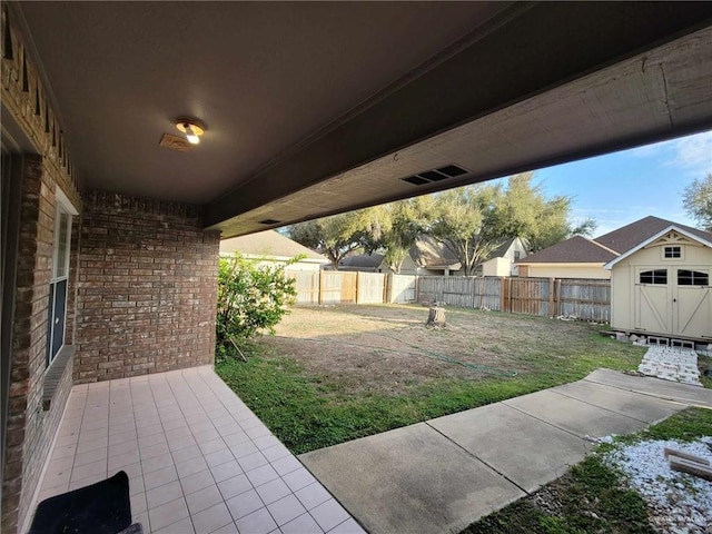 view of yard featuring a fenced backyard, an outbuilding, a storage shed, and a patio area