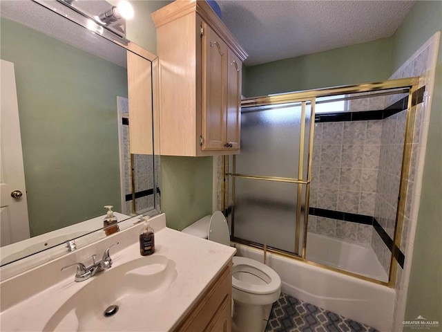 bathroom with vanity, toilet, combined bath / shower with glass door, and a textured ceiling