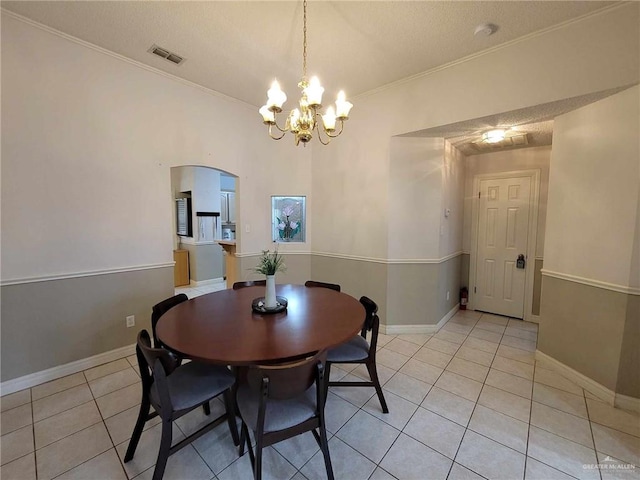 dining area with visible vents, an inviting chandelier, crown molding, light tile patterned floors, and baseboards