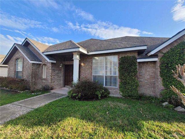 single story home featuring a front lawn, brick siding, and roof with shingles