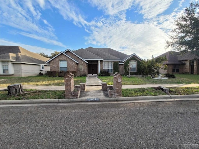 view of front of house featuring a front lawn and brick siding