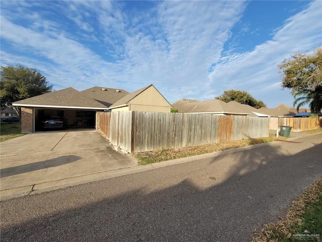 exterior space featuring a fenced front yard, an attached garage, and driveway