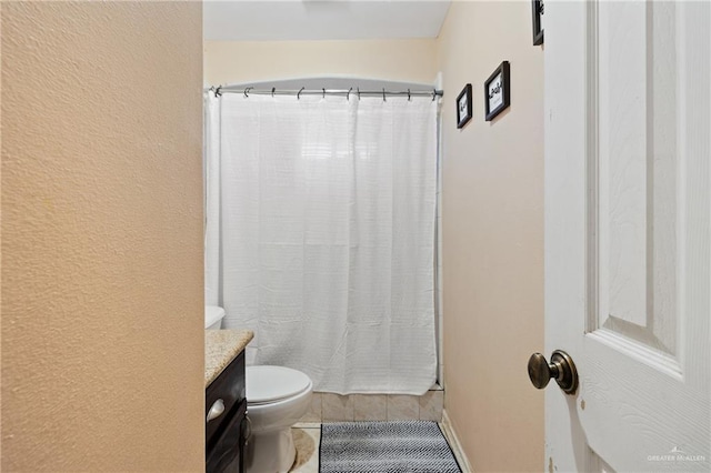 bathroom featuring toilet, tile patterned flooring, and vanity