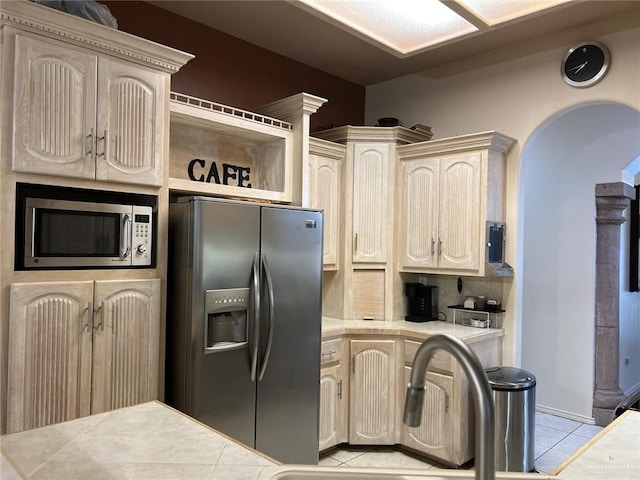 kitchen featuring tile counters, light tile patterned flooring, cream cabinetry, and appliances with stainless steel finishes