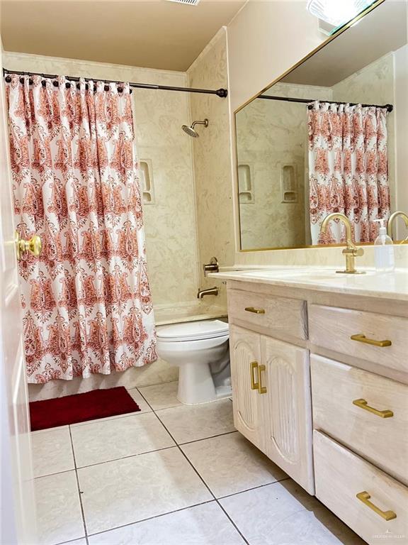 full bathroom with tile patterned flooring, vanity, shower / tub combo with curtain, and toilet