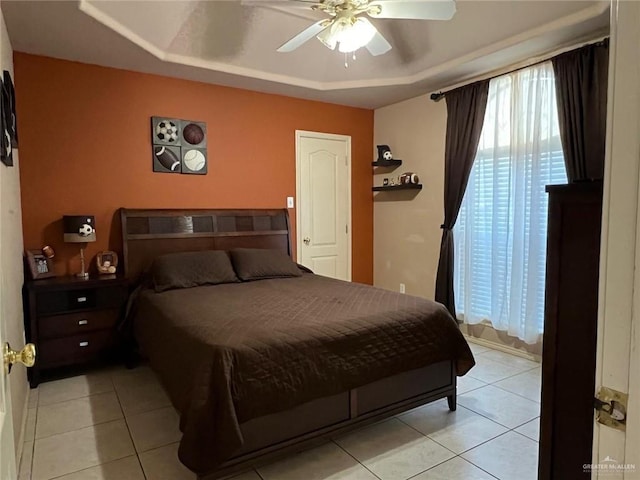 tiled bedroom featuring a tray ceiling and ceiling fan