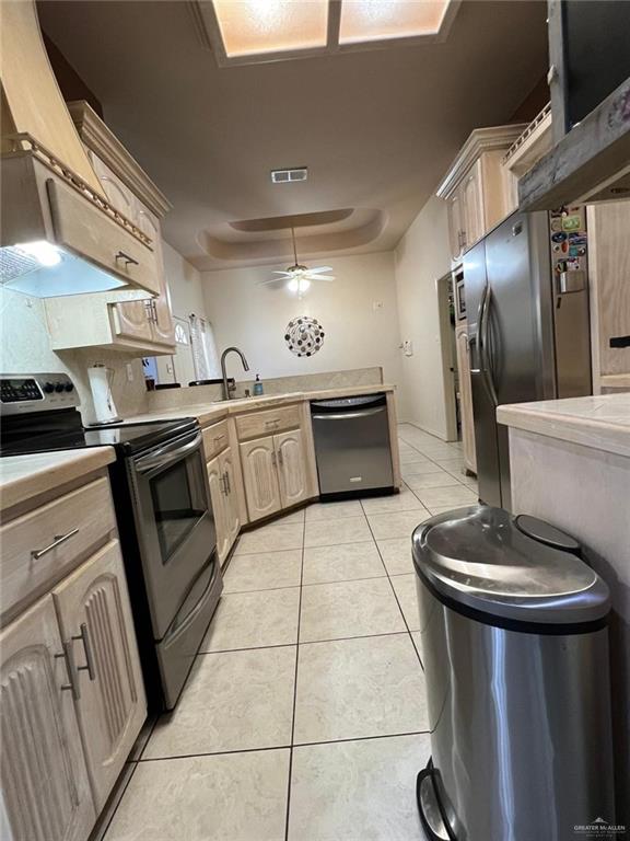 kitchen featuring sink, ceiling fan, light tile patterned floors, light brown cabinetry, and appliances with stainless steel finishes