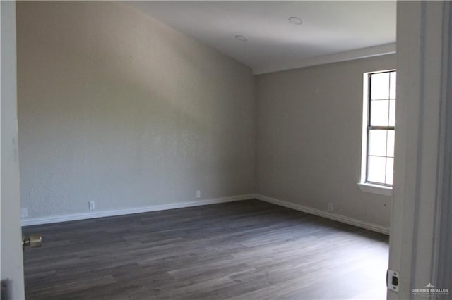 empty room with plenty of natural light and dark wood-type flooring