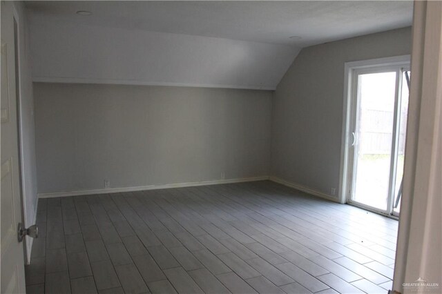 additional living space featuring hardwood / wood-style floors and vaulted ceiling