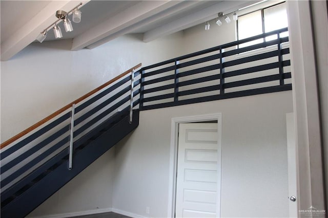 stairs with beam ceiling and rail lighting