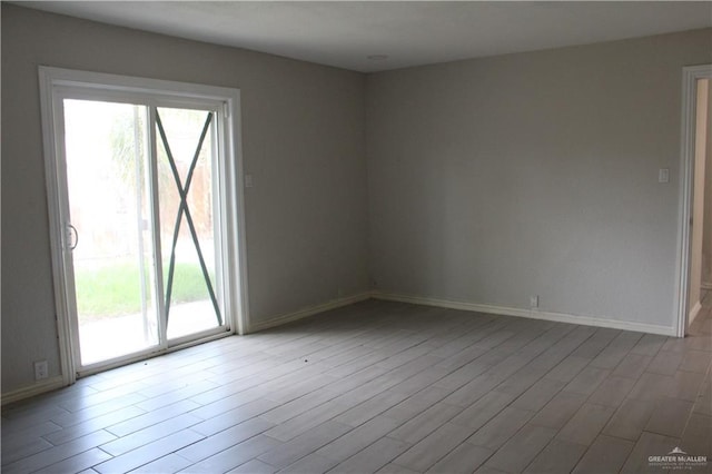 spare room featuring plenty of natural light and light hardwood / wood-style floors