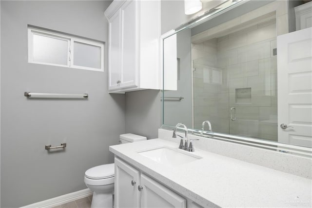 bathroom with tile patterned floors, vanity, toilet, and a shower with shower door