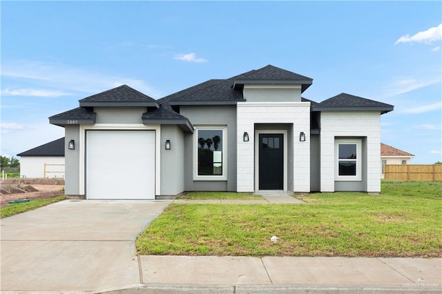 prairie-style home featuring a garage and a front lawn