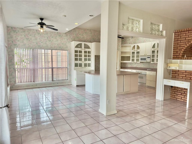 kitchen with ceiling fan, a center island, light tile patterned floors, and white appliances