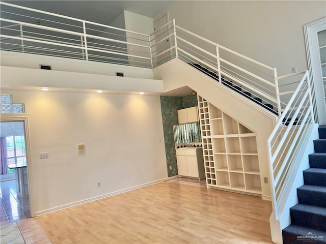 stairs featuring hardwood / wood-style flooring and a high ceiling