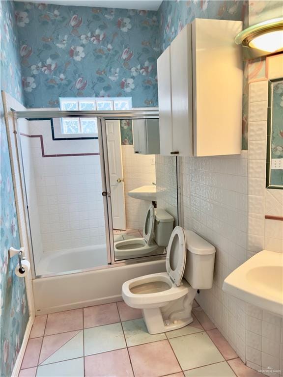 bathroom with tile patterned floors, toilet, and enclosed tub / shower combo