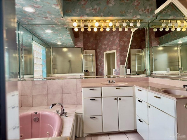 bathroom with tile patterned flooring, vanity, and a bath