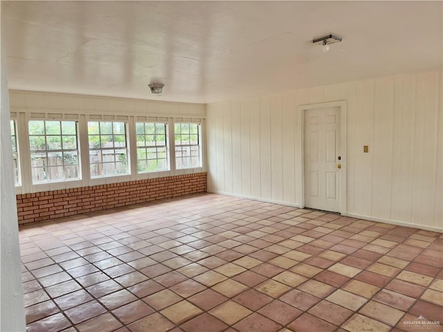 unfurnished room featuring wood walls