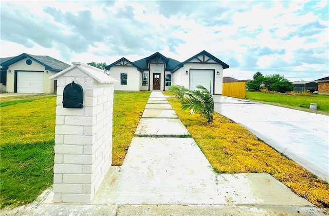 view of front of home with an attached garage, driveway, and a front yard