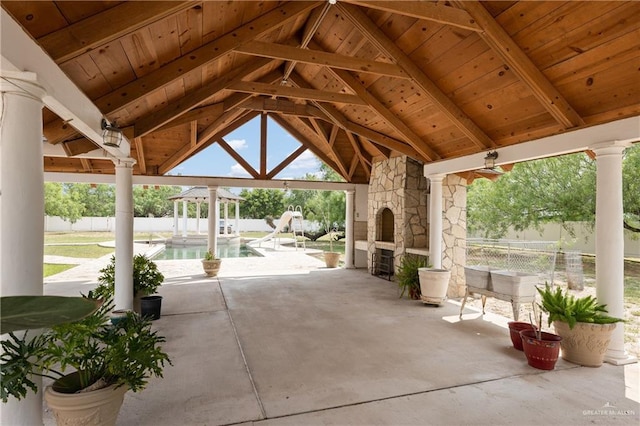 view of patio / terrace featuring a gazebo, a fireplace, and a fenced in pool