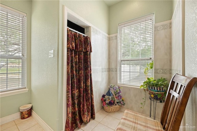 bathroom with a shower with curtain and tile patterned flooring