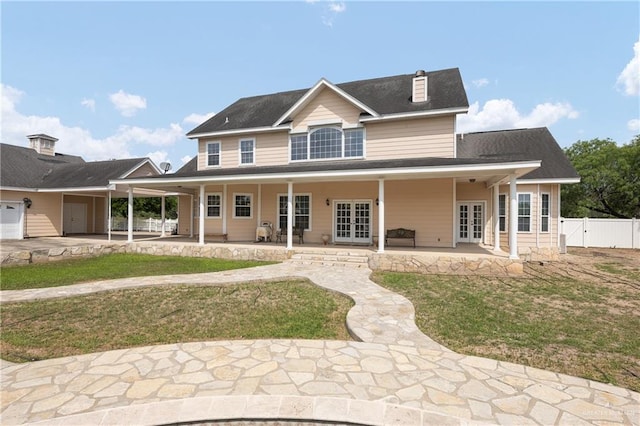 back of property with french doors, a patio, and a lawn