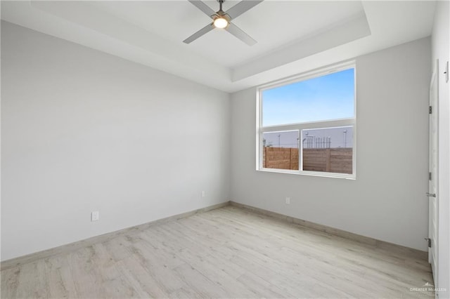 1216 N Lincoln Ave, San Juan, TX 78589 - empty room featuring wood finished floors, a raised ceiling, a ceiling fan, and baseboards