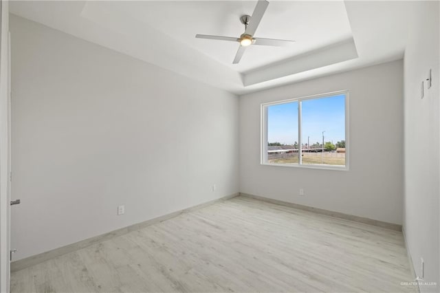 1216 N Lincoln Ave, San Juan, TX 78589 - spare room featuring light wood-type flooring, a raised ceiling, ceiling fan, and baseboards