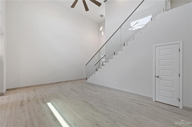1216 N Lincoln Ave, San Juan, TX 78589 - unfurnished living room with a ceiling fan, wood finished floors, a towering ceiling, stairs, and baseboards