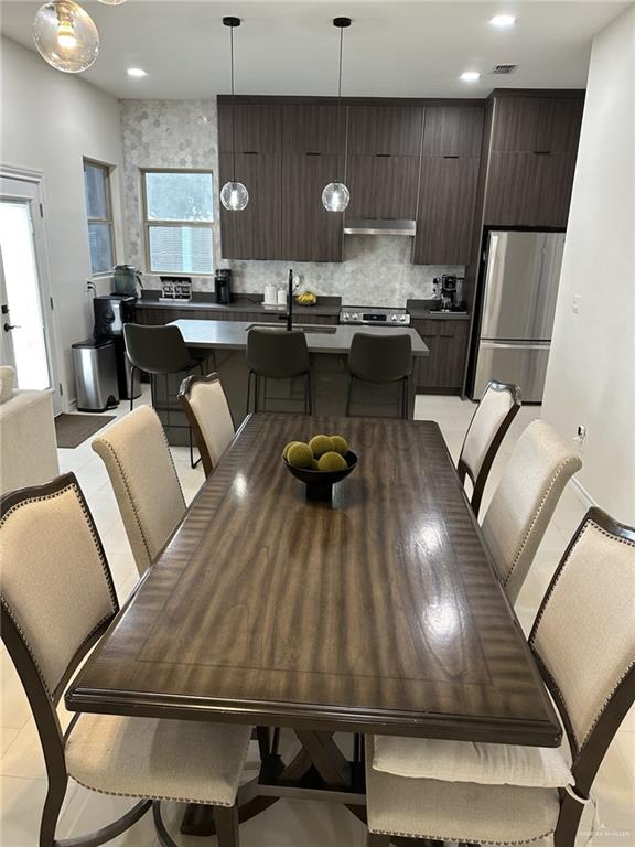 dining space with light tile patterned floors and sink