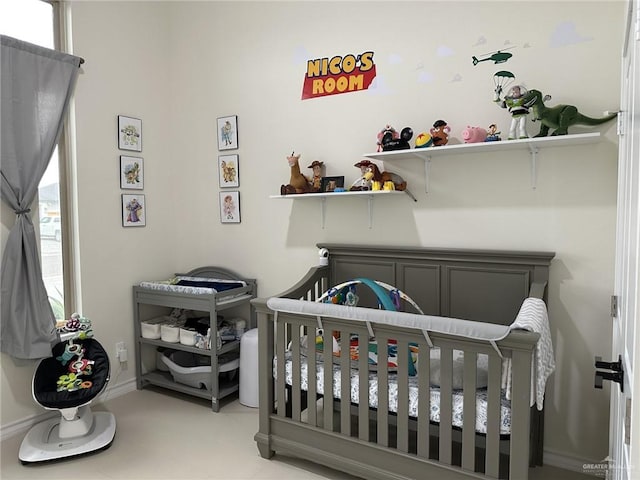 bedroom featuring multiple windows and a nursery area