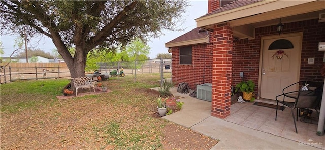 view of yard featuring a patio area, fence, and central air condition unit