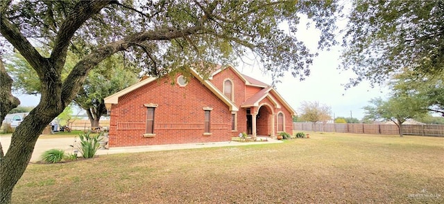 view of front of property with fence, a front lawn, and brick siding