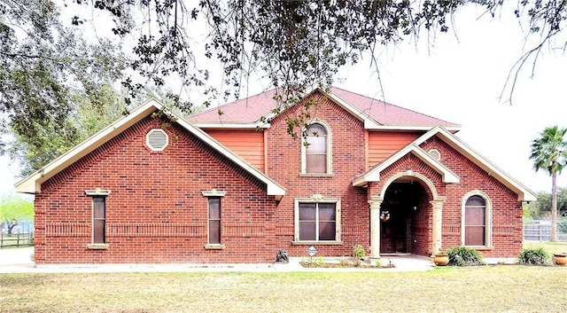 traditional home with a front yard and brick siding