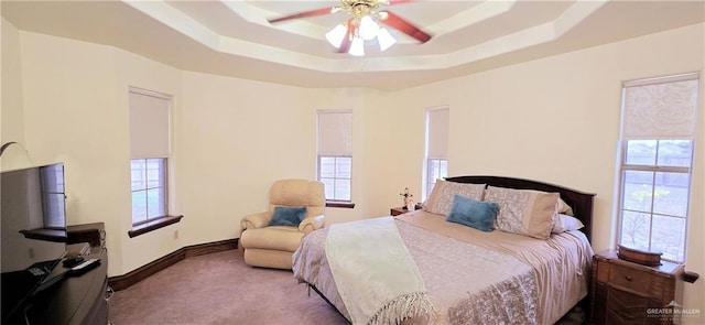 bedroom featuring ceiling fan, baseboards, a raised ceiling, and carpet flooring