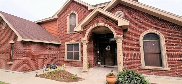 property entrance with brick siding and roof with shingles