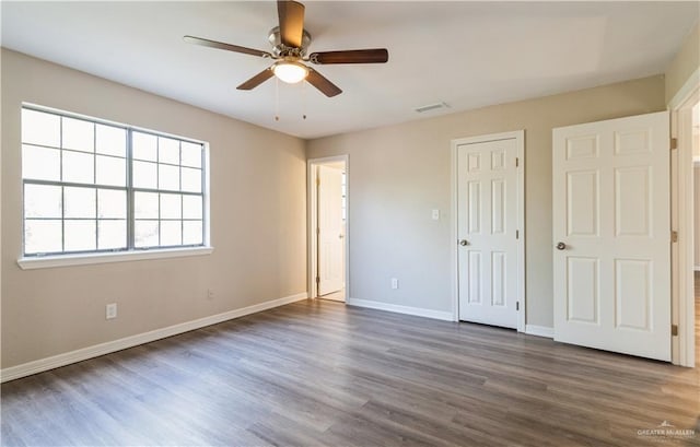 unfurnished bedroom with dark hardwood / wood-style flooring and ceiling fan