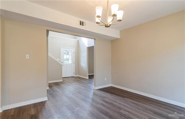 unfurnished room featuring a notable chandelier and dark hardwood / wood-style flooring