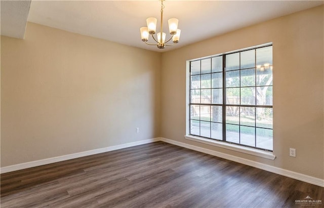 unfurnished room with dark wood-type flooring and an inviting chandelier