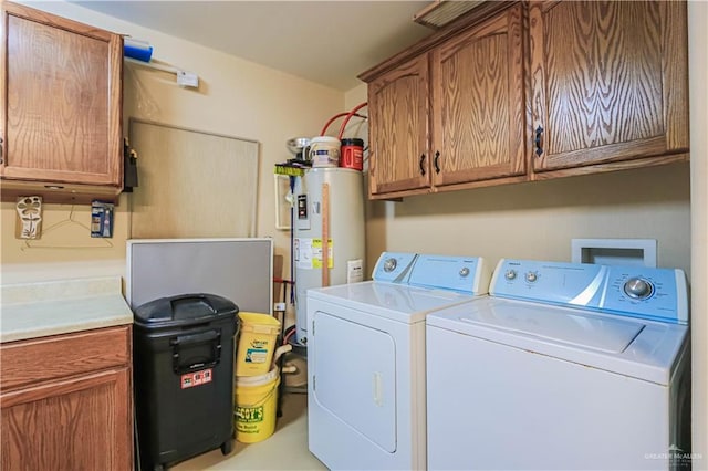 laundry room with cabinets, electric water heater, and washer and dryer