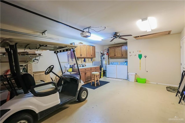 garage with a garage door opener, washing machine and dryer, and water heater